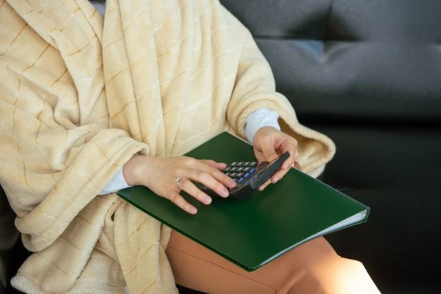 person using a calculator and binder